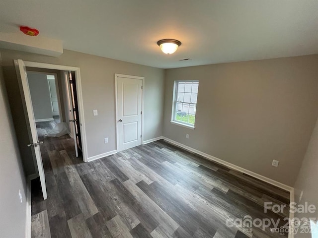 unfurnished bedroom featuring dark hardwood / wood-style floors