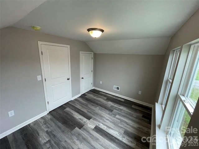 additional living space featuring vaulted ceiling and dark hardwood / wood-style flooring