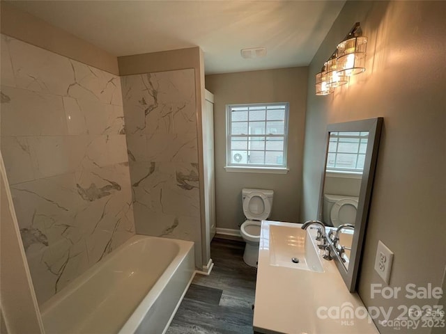 full bathroom featuring hardwood / wood-style floors, sink, toilet, and tiled shower / bath