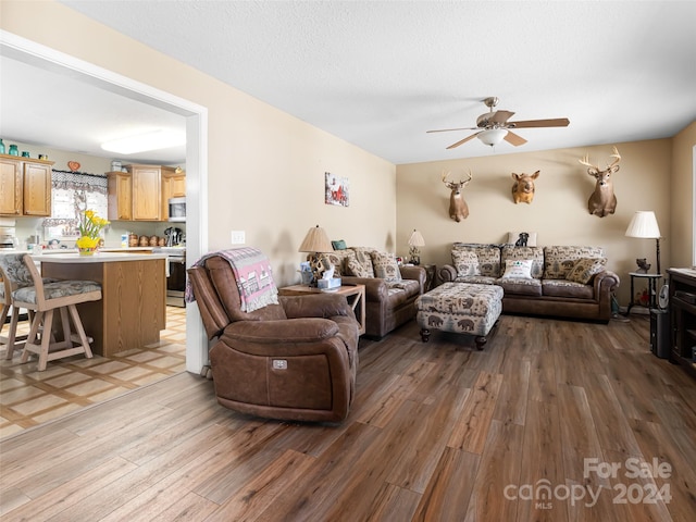 living room with tile floors and ceiling fan