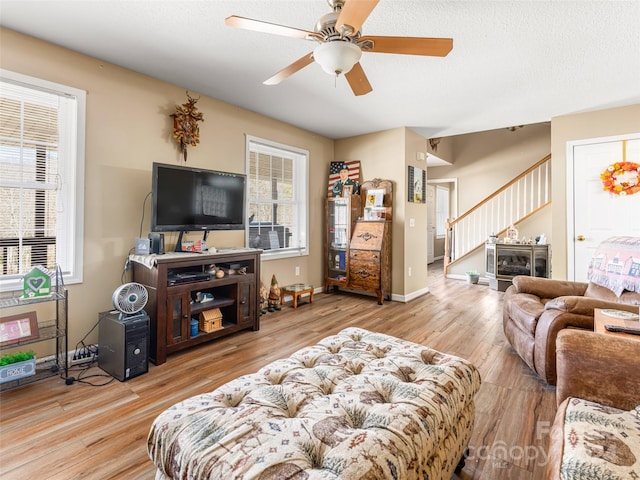 living room with plenty of natural light, light hardwood / wood-style floors, and ceiling fan