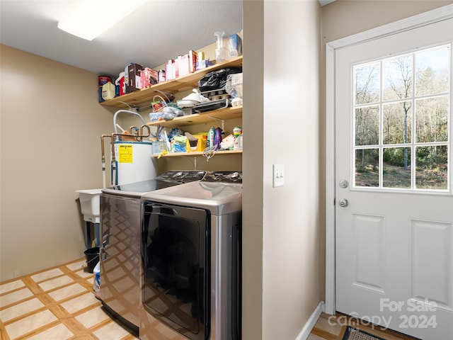 clothes washing area with washing machine and dryer, light tile flooring, and gas water heater