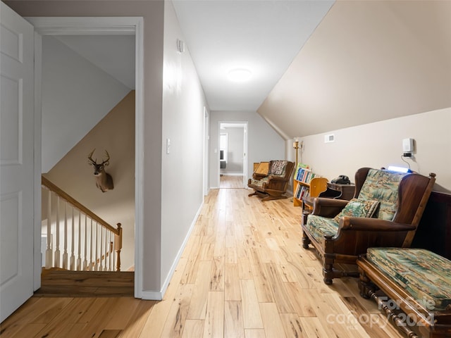 living area with light hardwood / wood-style floors and vaulted ceiling