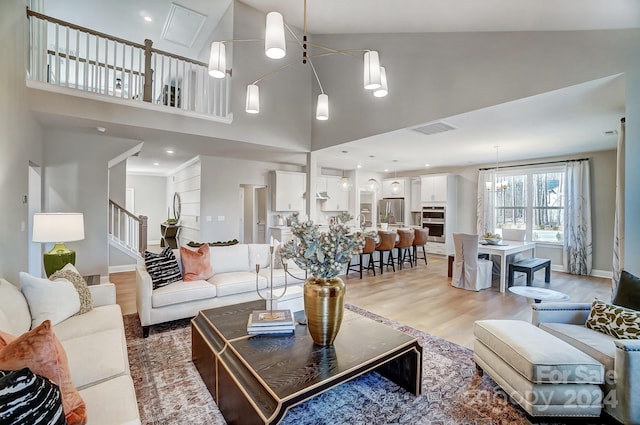 living room with high vaulted ceiling and light wood-type flooring