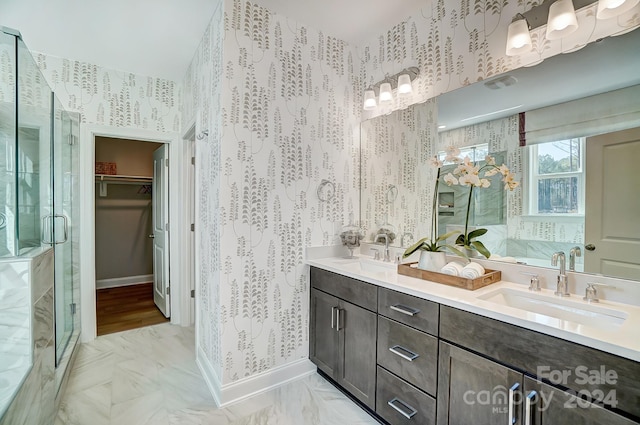 bathroom featuring dual sinks, tile flooring, an enclosed shower, and vanity with extensive cabinet space