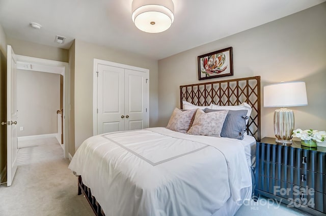 bedroom featuring light carpet and a closet