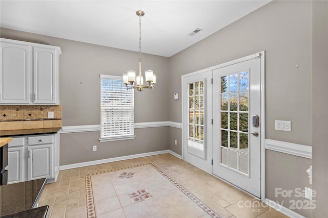 unfurnished dining area with an inviting chandelier