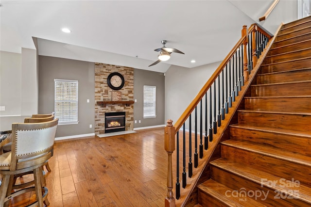 interior space with hardwood / wood-style floors, a large fireplace, a healthy amount of sunlight, and ceiling fan