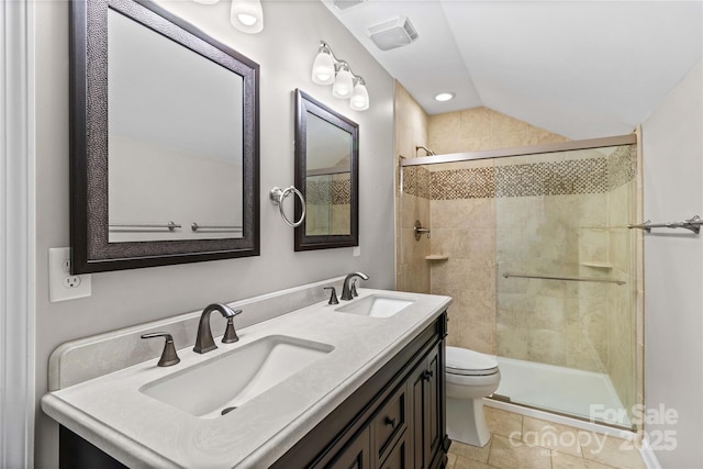 bathroom with a tile shower, lofted ceiling, vanity, toilet, and tile patterned floors