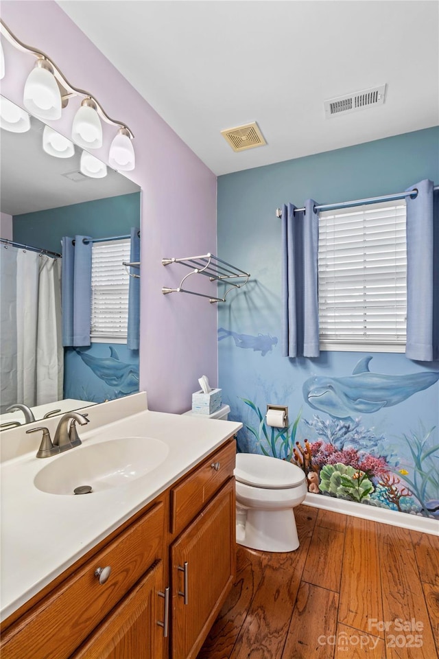 bathroom featuring vanity, hardwood / wood-style floors, and toilet