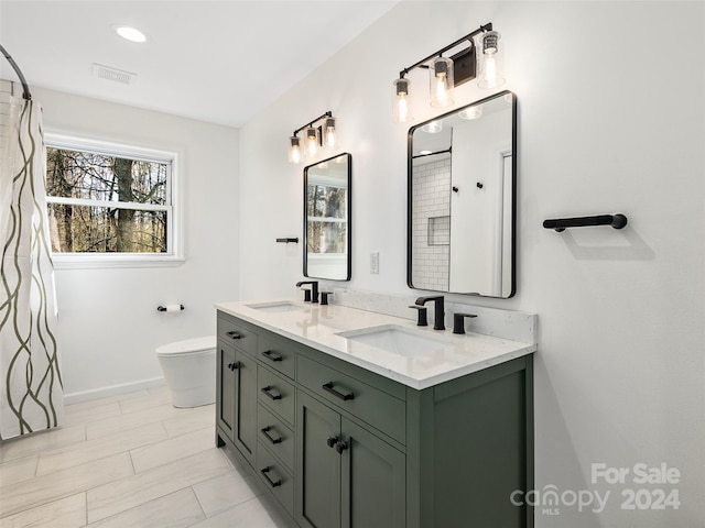 bathroom with toilet, vanity, and tile patterned flooring