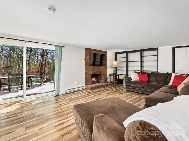 living room with a brick fireplace, light hardwood / wood-style floors, and a baseboard radiator