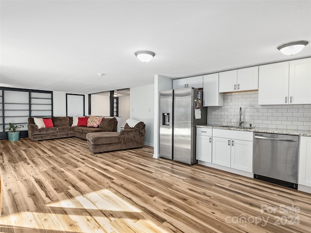 kitchen with light wood-type flooring, sink, stainless steel appliances, and white cabinetry