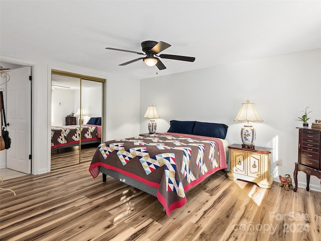 bedroom with ceiling fan, a closet, and hardwood / wood-style flooring