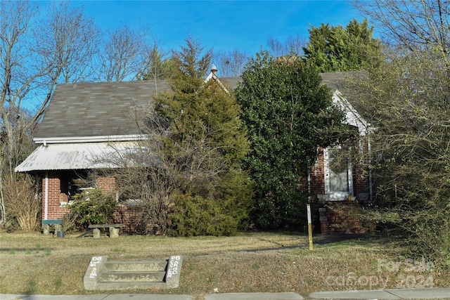 obstructed view of property with a front lawn