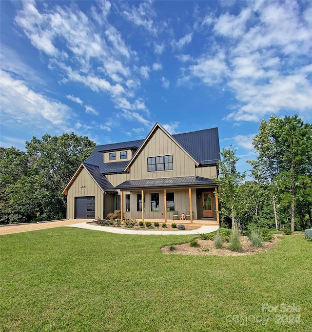 view of front of home with a garage, a front lawn, and a porch