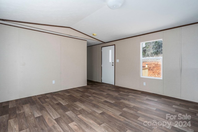 empty room with dark hardwood / wood-style floors and vaulted ceiling