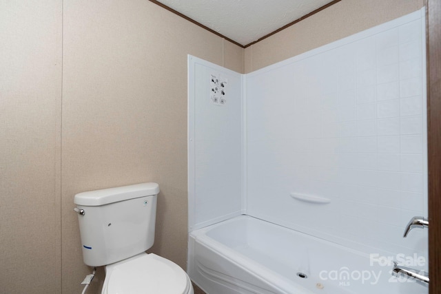 bathroom with crown molding, bathing tub / shower combination, toilet, and a textured ceiling