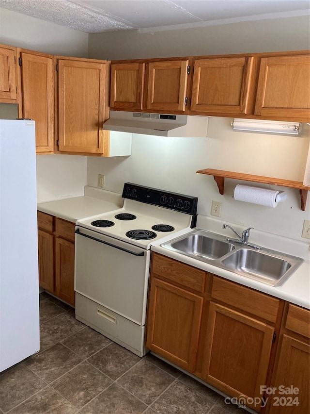 kitchen featuring white appliances, sink, and a textured ceiling