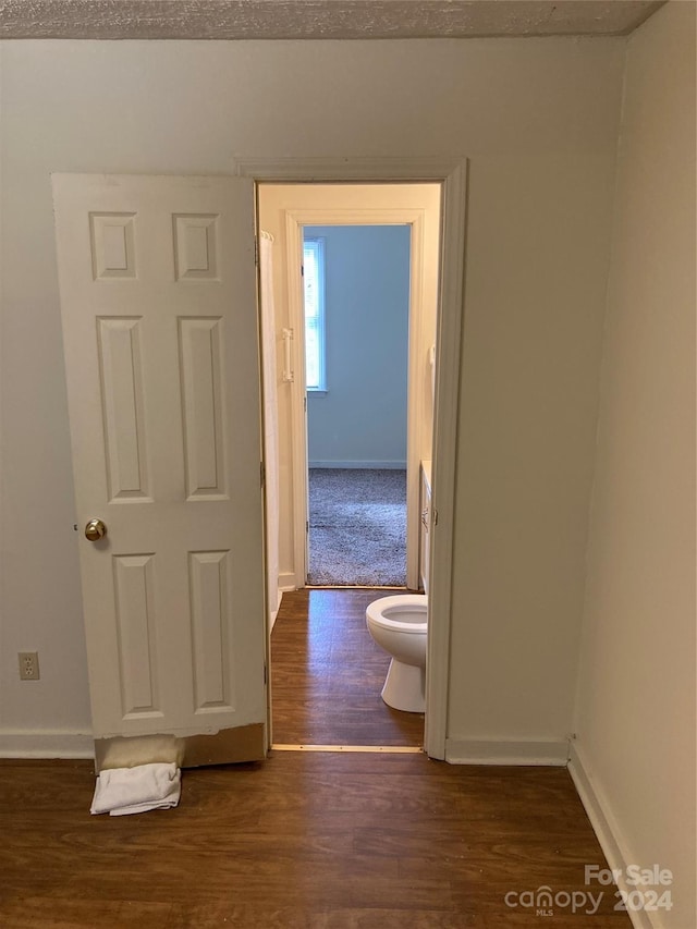 bathroom with a textured ceiling, toilet, and hardwood / wood-style flooring