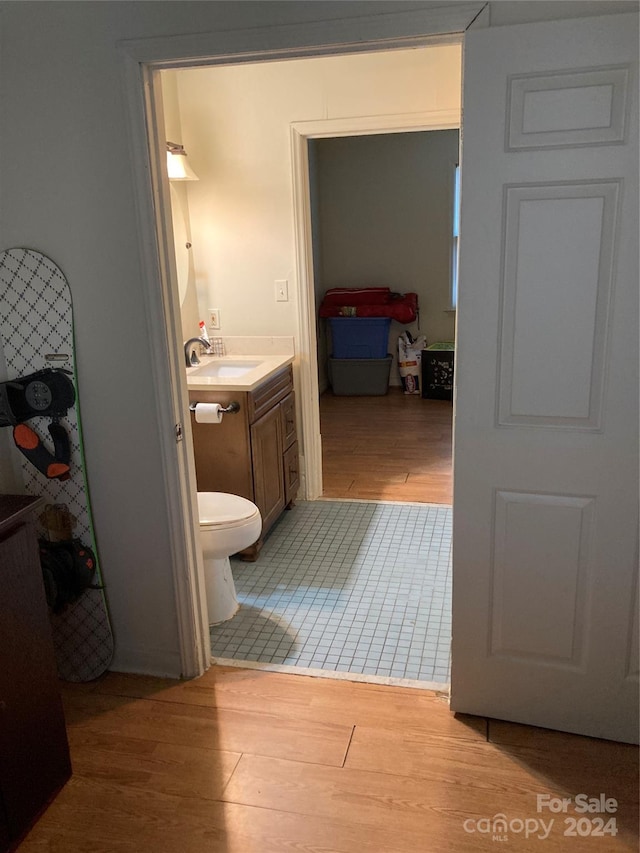 bathroom with vanity, toilet, and wood-type flooring