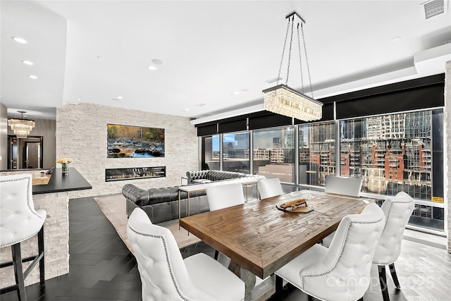 dining space featuring parquet flooring and a fireplace