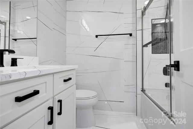 full bathroom featuring tile walls, tile floors, enclosed tub / shower combo, large vanity, and toilet