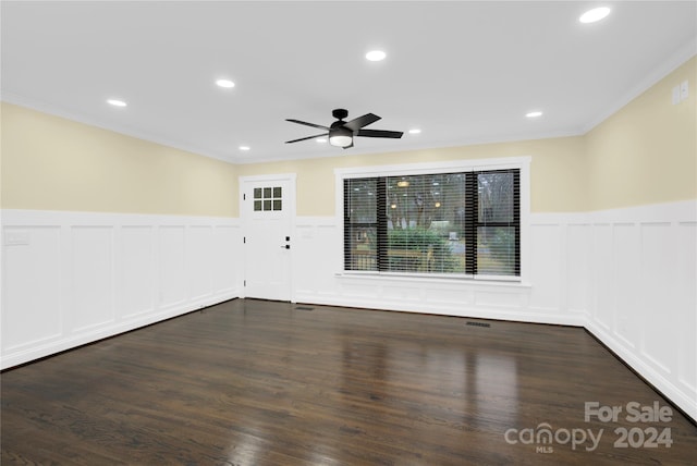 spare room featuring dark hardwood / wood-style floors, ceiling fan, and ornamental molding