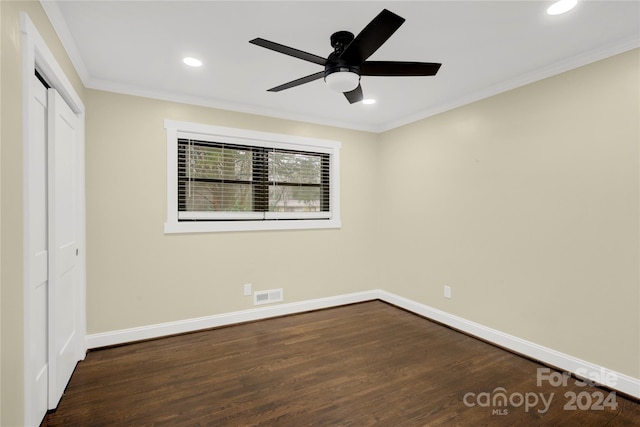 unfurnished room featuring dark hardwood / wood-style flooring, ceiling fan, and crown molding