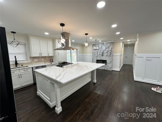 kitchen featuring a kitchen island, decorative light fixtures, white cabinetry, fume extractor, and dark hardwood / wood-style floors