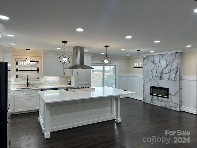 kitchen featuring dark hardwood / wood-style flooring, light stone counters, white cabinetry, and wall chimney exhaust hood