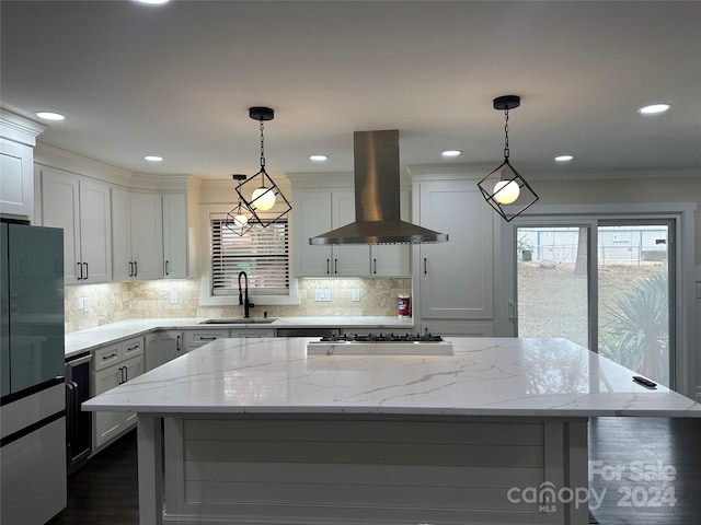 kitchen featuring decorative light fixtures, light stone counters, a center island, island exhaust hood, and sink