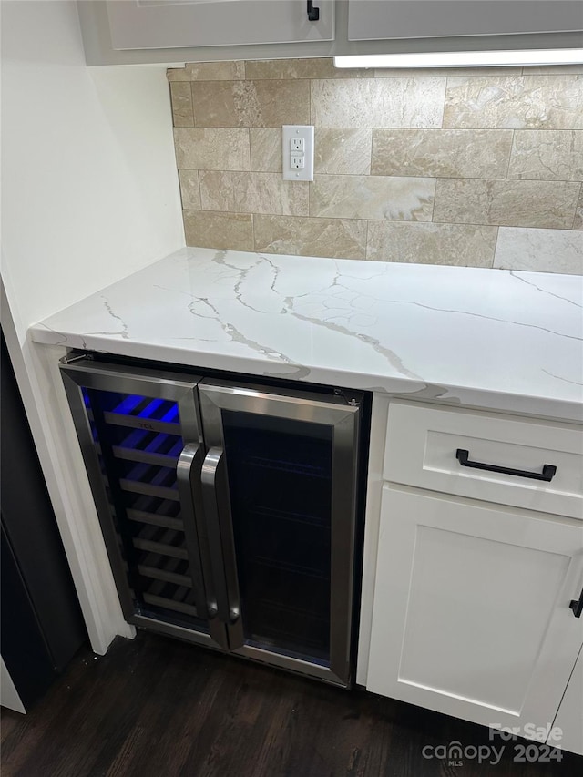 room details featuring beverage cooler, bar area, backsplash, and dark hardwood / wood-style floors