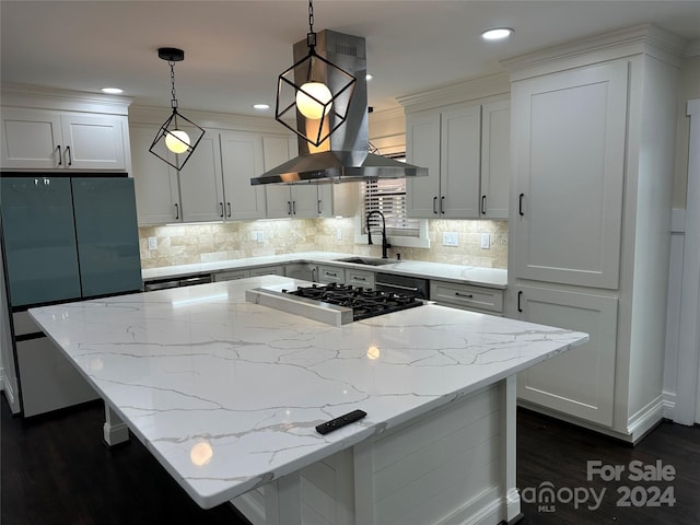 kitchen featuring decorative light fixtures, white cabinets, a kitchen island, and island exhaust hood