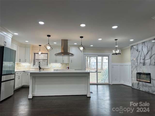 kitchen with decorative light fixtures, stainless steel fridge, dark wood-type flooring, island exhaust hood, and ornamental molding