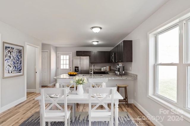 dining area with sink and light wood-type flooring