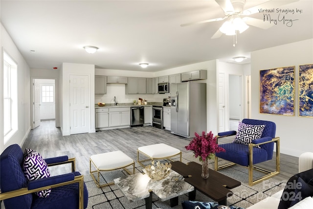 living room with ceiling fan, light hardwood / wood-style flooring, and sink