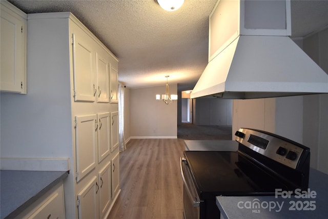 kitchen with stainless steel electric stove, white cabinetry, island exhaust hood, and a textured ceiling