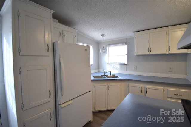 kitchen with decorative light fixtures, sink, white cabinetry, and white fridge