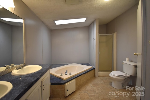 full bathroom with a textured ceiling, independent shower and bath, a skylight, and vanity