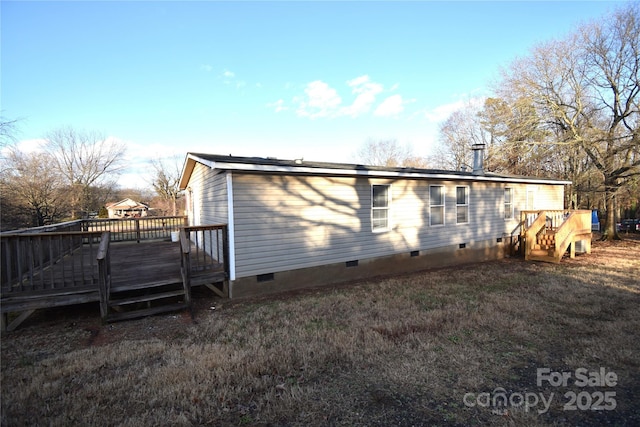 rear view of house featuring a lawn and a deck