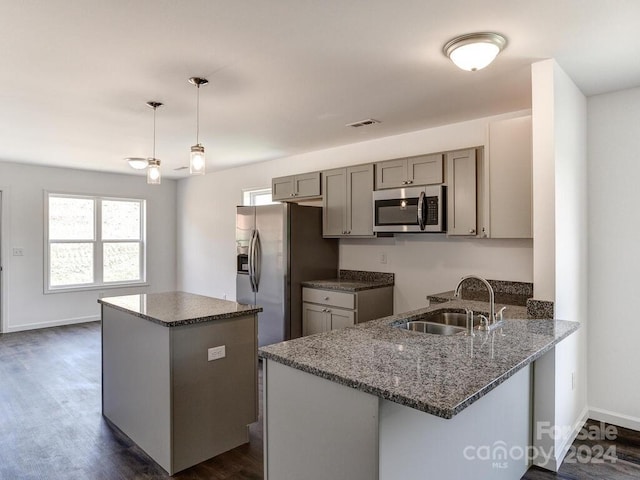 kitchen featuring dark hardwood / wood-style floors, sink, gray cabinetry, appliances with stainless steel finishes, and decorative light fixtures