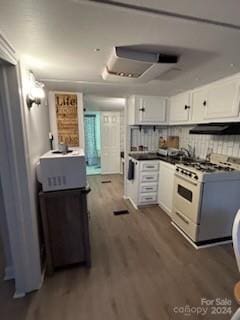 kitchen featuring dark wood-type flooring, white gas range oven, white cabinetry, backsplash, and extractor fan