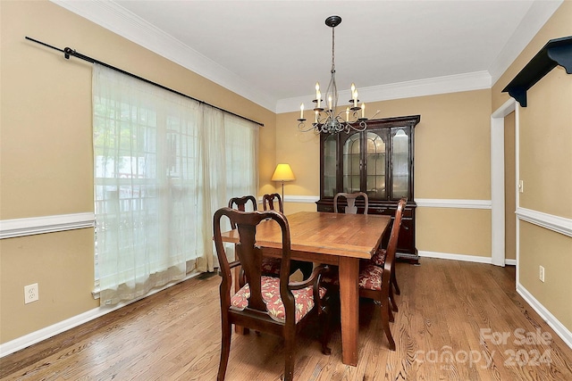 dining room with hardwood / wood-style flooring, ornamental molding, and a chandelier