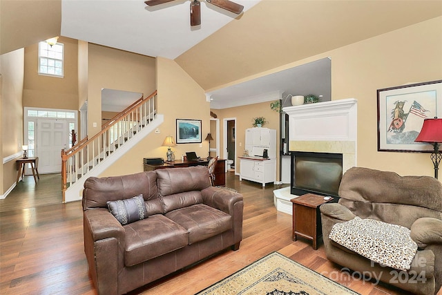 living room featuring hardwood / wood-style floors, a towering ceiling, and ceiling fan