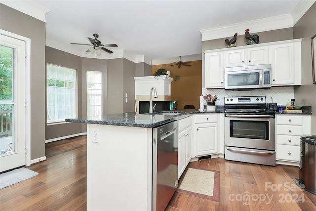 kitchen with sink, appliances with stainless steel finishes, tasteful backsplash, white cabinets, and dark hardwood / wood-style flooring