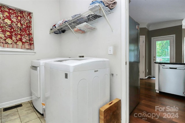 washroom featuring washing machine and clothes dryer, ornamental molding, and tile patterned flooring