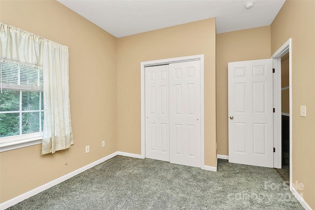 unfurnished bedroom featuring dark carpet and a closet