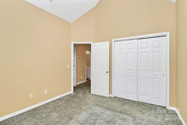 unfurnished bedroom with high vaulted ceiling, carpet floors, and a closet