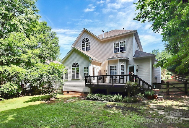 rear view of house with a yard and a deck